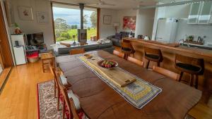 een keuken en een woonkamer met een tafel en stoelen bij The Orange House in Premaydena