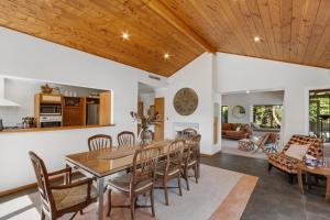 a dining room and living room with a wooden ceiling at Hikanui Haven - Havelock North Holiday Home in Havelock North