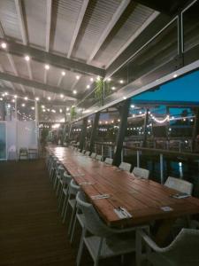 una larga mesa de madera y sillas en un restaurante en Spacious Waterfront Apartment Couran Cove, en South Stradbroke