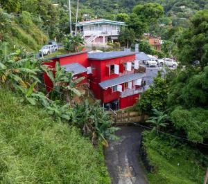 una casa rossa sul fianco di una collina di Castara Cottage by Hello Mello a Castara