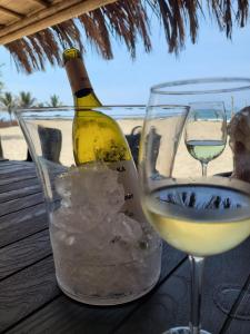 Una botella de vino blanco y una copa de hielo. en Las Hamacas, en Canoas de Punta Sal