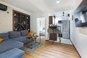 a living room with a gray couch and a brick wall at Apartment Paradise Resavska in Belgrade