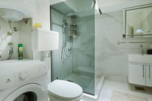 a white bathroom with a washing machine and a sink at Apartment Paradise Resavska in Belgrade