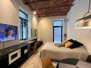 a bedroom with two beds and a flat screen tv at Loft Suite in Lappeenranta