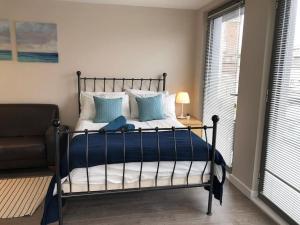 a bed with blue and white pillows in a bedroom at STUDIO Apartment opposite shoreditch Park in London