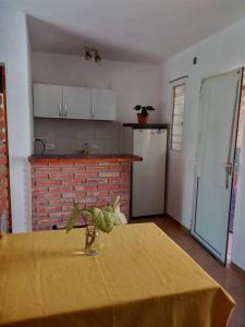 una cocina con una mesa con un mantel amarillo. en Monoambiente Carlos Paz en Villa Carlos Paz