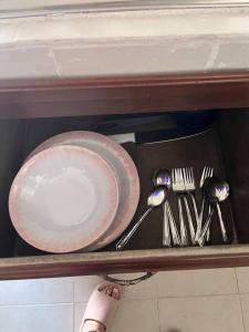 a table with plates and utensils on a shelf at Flores Condominios Depa Lili in Álamos
