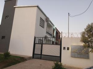 a white building with a gate on the side of it at LA ÑATA in Concepción del Uruguay