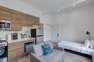 a kitchen with a couch and a bed in a room at Ground Floor Studios in Chicago by 747 Lofts in Chicago