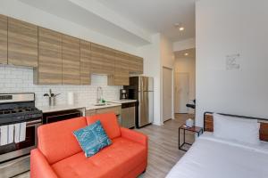 a living room with an orange couch and a kitchen at Ground Floor Studios in Chicago by 747 Lofts in Chicago