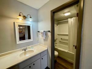 a bathroom with a sink and a toilet and a mirror at Alpine Village Inn in Helen +20 photos