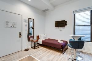 a bedroom with a bed and a tv and a chair at Chicago Second Floor Studio by 747 Lofts in Chicago