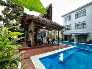 ein Haus mit einem Pool und einer Terrasse mit einem Haus in der Unterkunft Siargao Seasky Resort in Catagnan