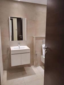 ein Badezimmer mit Waschbecken, Spiegel und Toilette in der Unterkunft Schone, ruhige neuwertige, 127 qm Fewo in Sidi Daoud