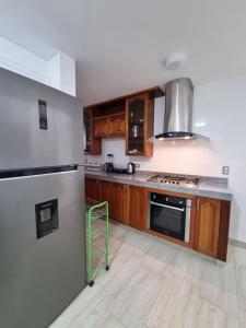 una cocina con armarios de madera y electrodomésticos de acero inoxidable en APARTAMENTO DE 3 DORMITORIOS EN LA MOLINA, en Lima