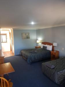 een hotelkamer met 2 bedden en een tafel bij Asters On James Motor Inn in Toowoomba