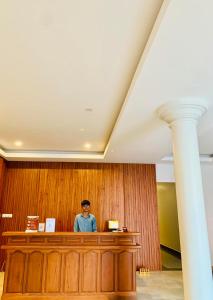 a man is standing at a desk in a courtroom at Laluna Guesthouse in Siem Reap