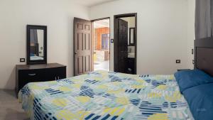 - une chambre avec un lit et un miroir dans l'établissement Villa Don Pedro - Casa de descanso, à San Pedro de la Laguna