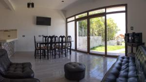 Villa Don Pedro - Casa de descanso في سان بيدرو لا لاغونا: غرفة معيشة مع طاولة طعام وكراسي