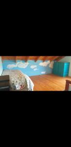 sypialnia z łóżkiem z chmurami malowanymi na ścianie w obiekcie Cabaña Thaqu w mieście Merlo