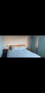Schlafzimmer mit einem Bett mit blauer Decke in der Unterkunft Cabaña Thaqu in Merlo