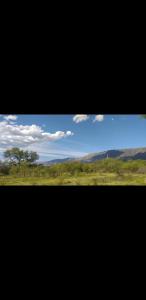 einen Blick auf ein Grasfeld und einen blauen Himmel in der Unterkunft Cabaña Thaqu in Merlo