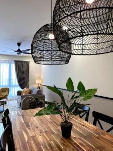 una sala de estar con una mesa con una planta en The Apple Premier Condo in melaka en Melaka