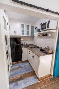 a kitchen with white cabinets and a black refrigerator at Amazing Apartments Juan Dolio, El Bonito II - 2A in Juan Dolio