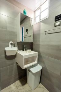 a bathroom with a sink and a toilet and a mirror at Amazing Apartments Juan Dolio, El Bonito II - 2A in Juan Dolio