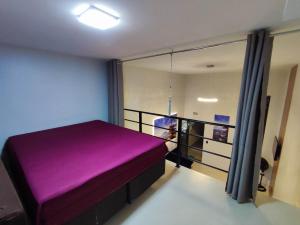 a purple bed in a room with a window at GUARATUBA LOFTS in Guaratuba