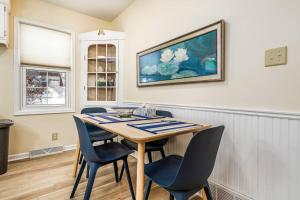 a dining room table with chairs and a painting on the wall at Oaklie's Bungalow - Charming Home in Dubuque in Dubuque