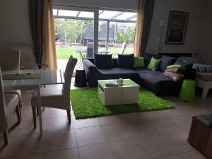 a living room with a couch and a table at Ebenerdig mit Terrasse & Garten, WLAN & Parkplatz! Self Check-in & Check-out! Schwedenofen! in Auggen