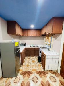 uma cozinha com armários de madeira e um tecto azul em Coco Bahia Apartment em Six Huts