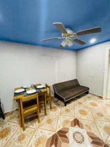 a living room with a ceiling fan and a table at Coco Bahia Apartment in Six Huts