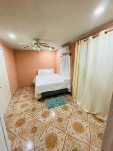 a bedroom with a bed and a tiled floor at Coco Bahia Apartment in Six Huts