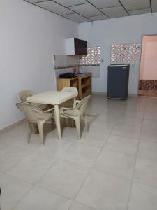 a kitchen with a table and chairs and a refrigerator at Guio Apartamentos in San Antero