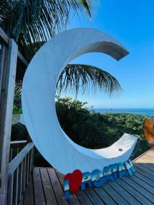 a large white surfboard on a deck with the ocean at Bahia Azul Apartment in Six Huts