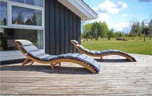 Dos bancos sentados en una terraza junto a una casa. en Nice Home In Glesborg With Sauna, en Glesborg 26 fotos más