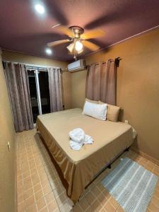 1 dormitorio con 1 cama y ventilador de techo en Mr, Crab Apartment, en Six Huts
