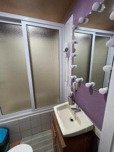 baño con paredes de color púrpura, lavabo y espejos en Mr, Crab Apartment, en Six Huts