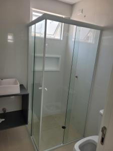 a glass shower in a bathroom with a sink at Recanto Meia Praia in Itapema