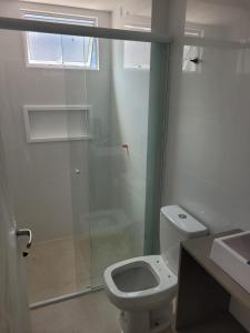 a bathroom with a shower and a toilet and a sink at Recanto Meia Praia in Itapema