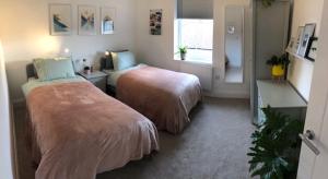 a bedroom with two beds and a window at Brooklands Hideaway in Scarborough
