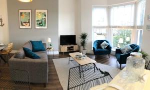 a living room with a couch and chairs and a tv at Brooklands Hideaway in Scarborough