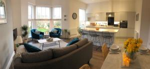 a living room with two couches and a kitchen at Brooklands Hideaway in Scarborough