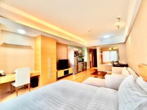 a hotel room with a bed and a living room at Tianjin Crown International Apartment in Tianjin