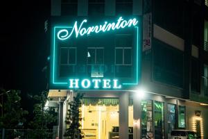 峇株巴辖Norvinton Hotel的大楼一侧的 ⁇ 虹酒店标志