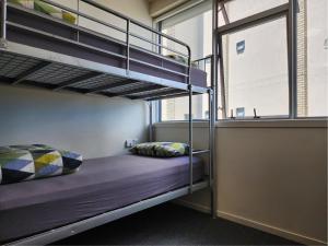 オークランドにあるNewton Lodge Aucklandの窓付きの部屋の二段ベッド1台分です。