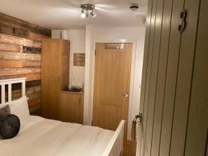 a bedroom with a white bed and a wooden wall at The Dukes in Leighton Buzzard