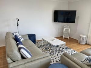 a living room with a couch and a table at Bermagui Beach Apartment in Bermagui